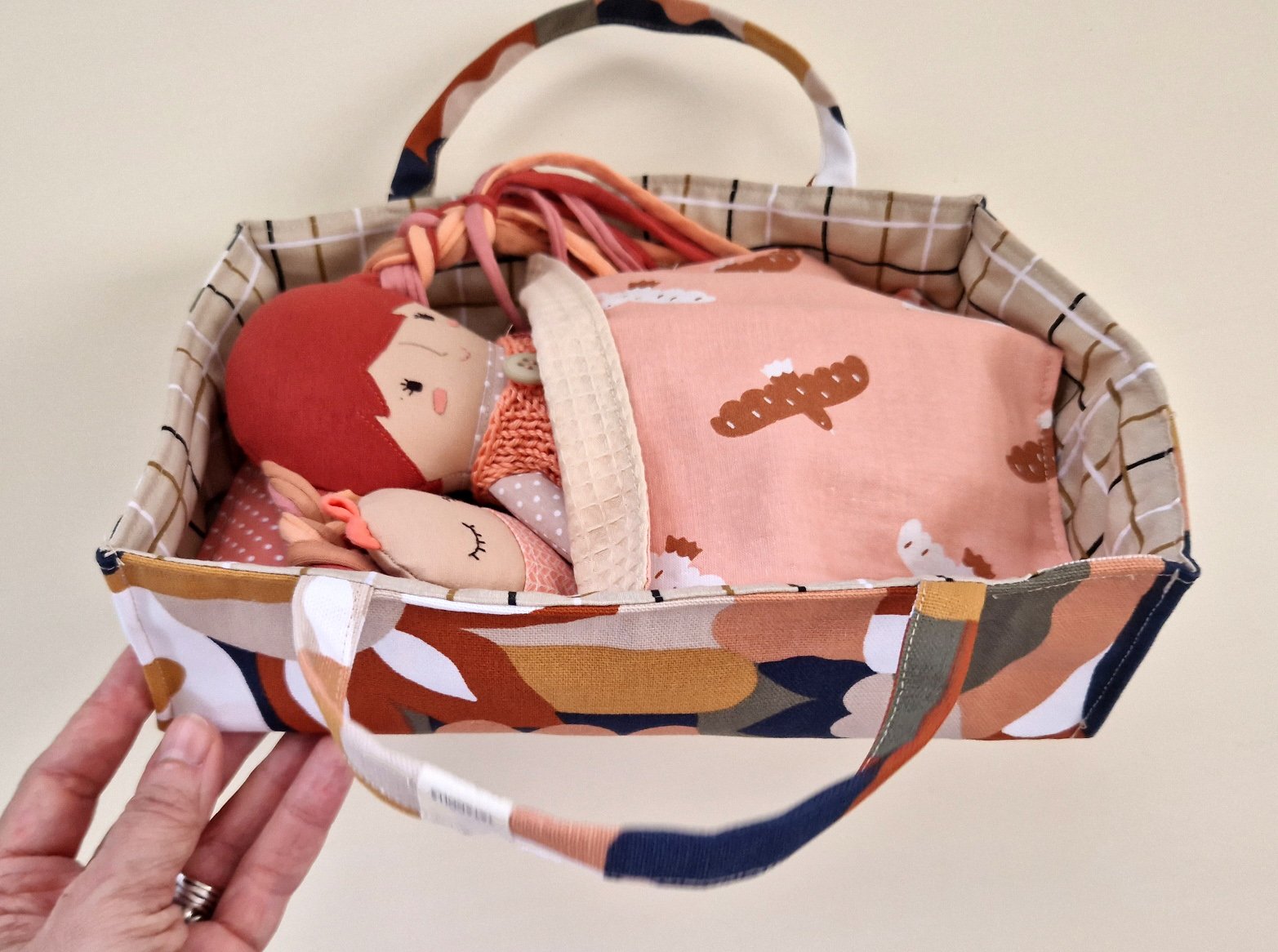 Play doll set including a fabric bag, colorful clothes, a small handbag, and accessories.