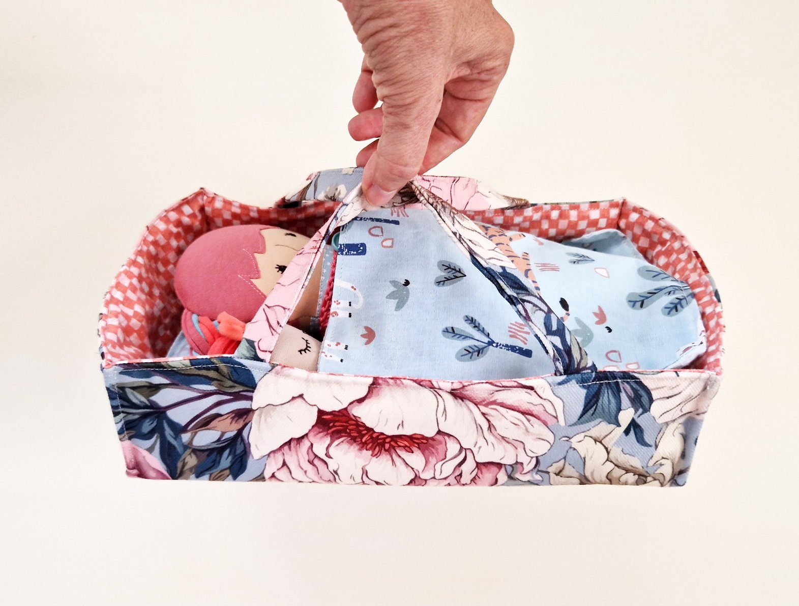 Portable doll bed with colorful bedding and play clothes