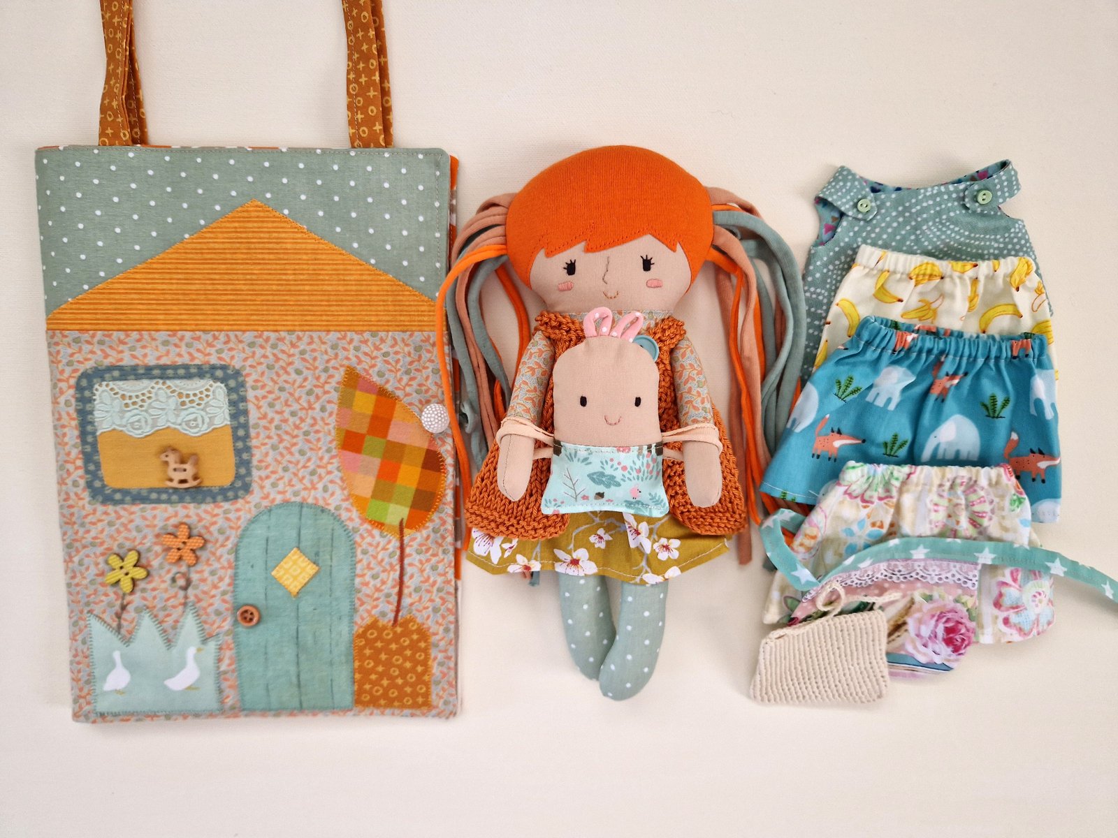 Portable fabric doll house with a small wardrobe and interchangeable clothes