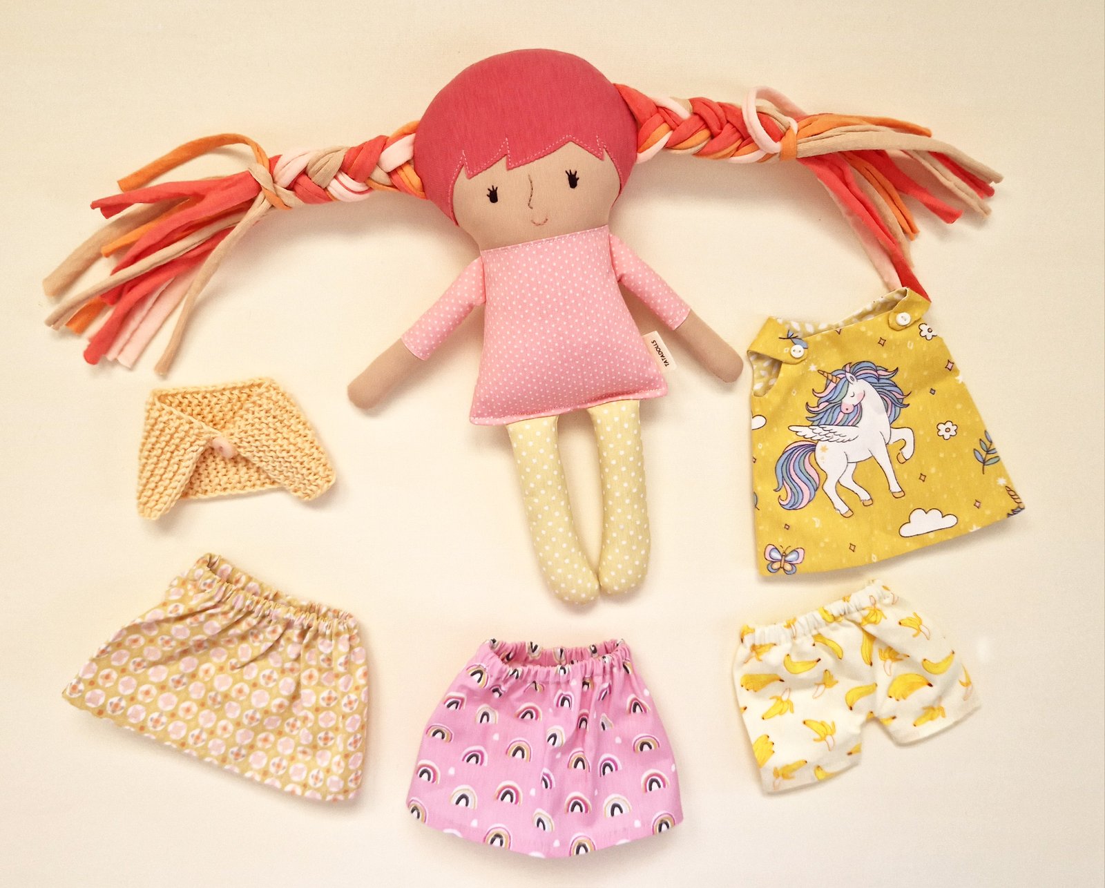 Play doll with long braided fabric hair and a unicorn print dress.