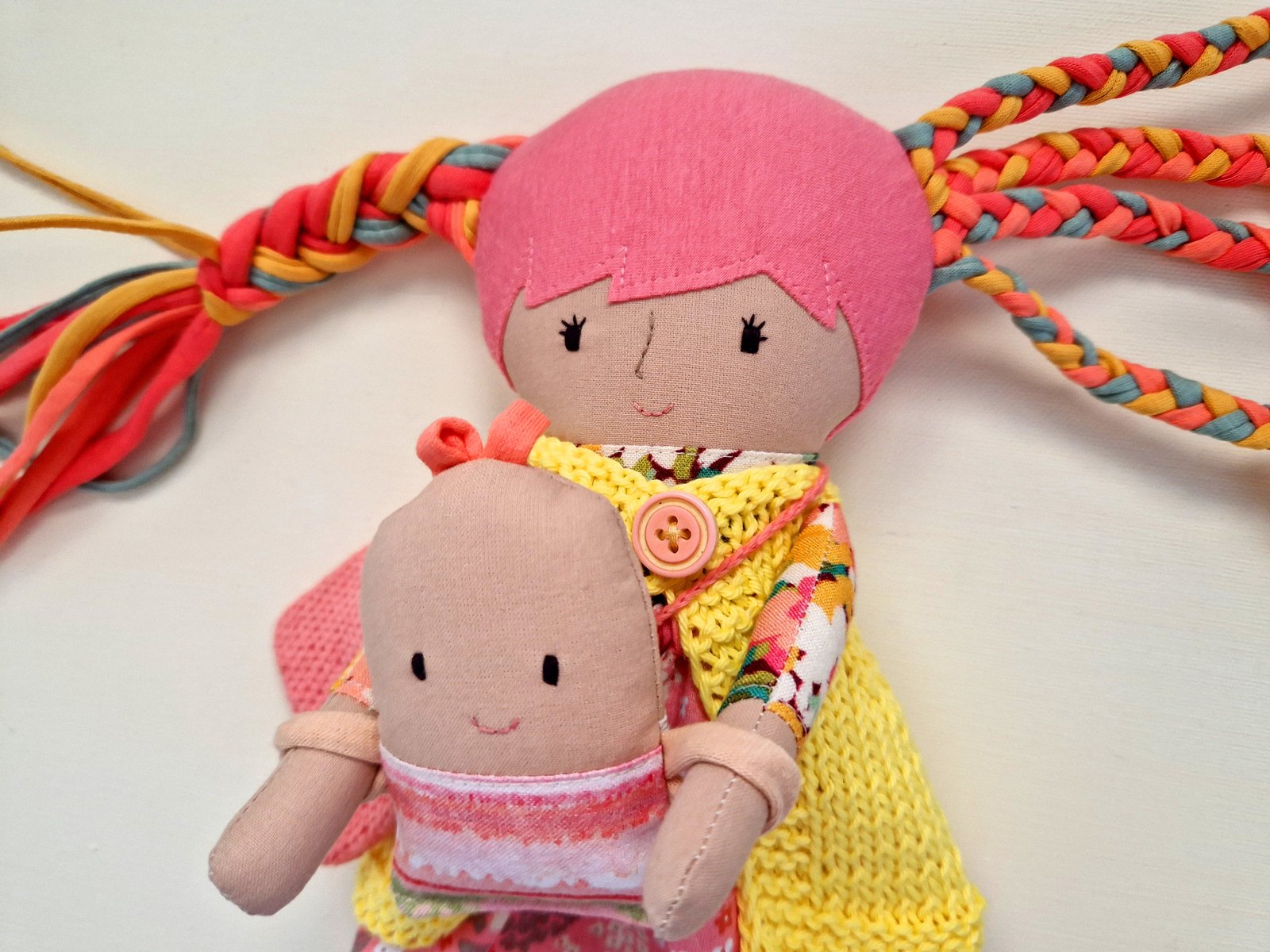 Children's cloth doll with long colorful hair and a selection of clothes and accessories.