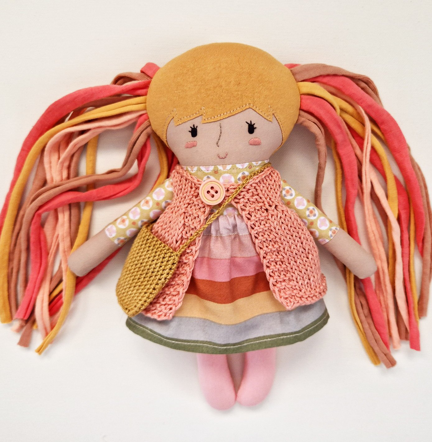 Large fabric doll holding a small baby doll against a light background.
