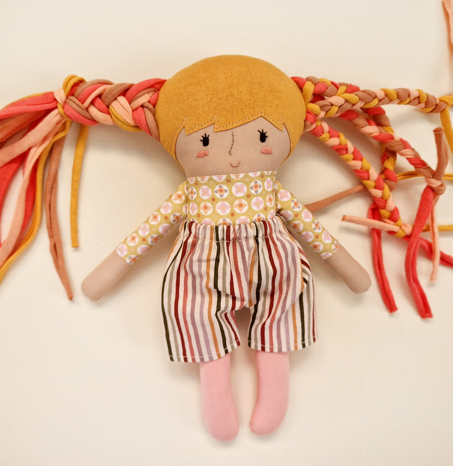 Colorful play doll with long hair and a fabric baby doll accessory.