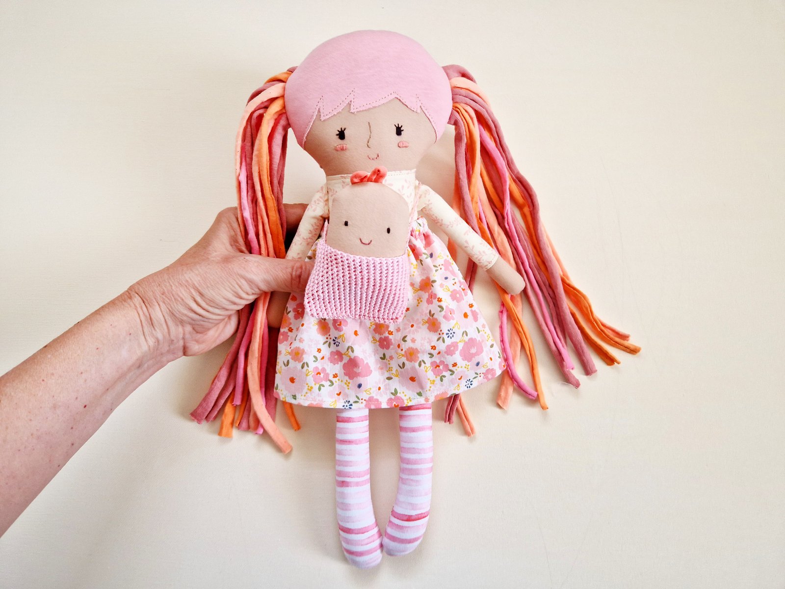 Play set featuring a large fabric doll, a small baby doll, and interchangeable clothing.