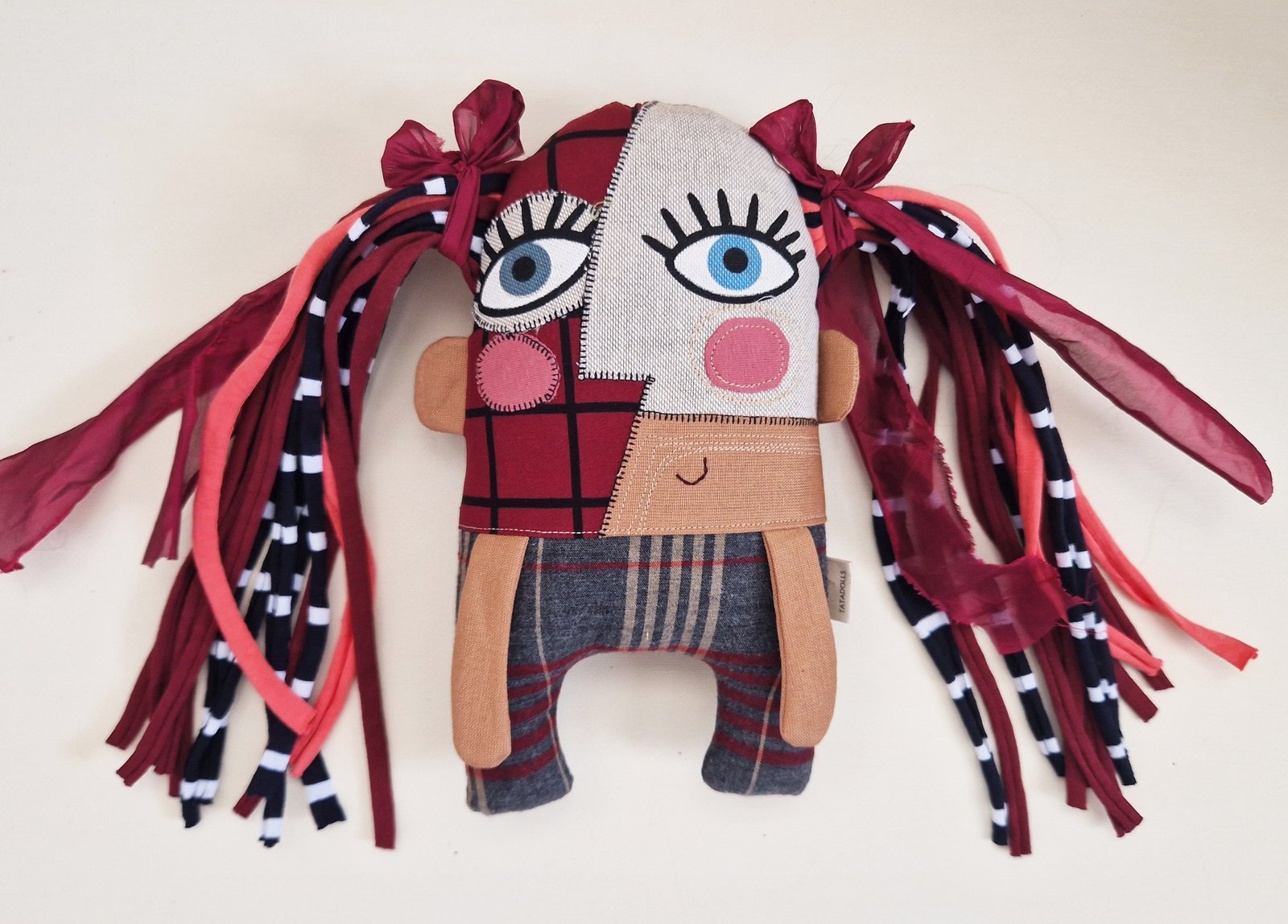 Original handmade fabric doll with an asymmetrical face and large blue eyes.