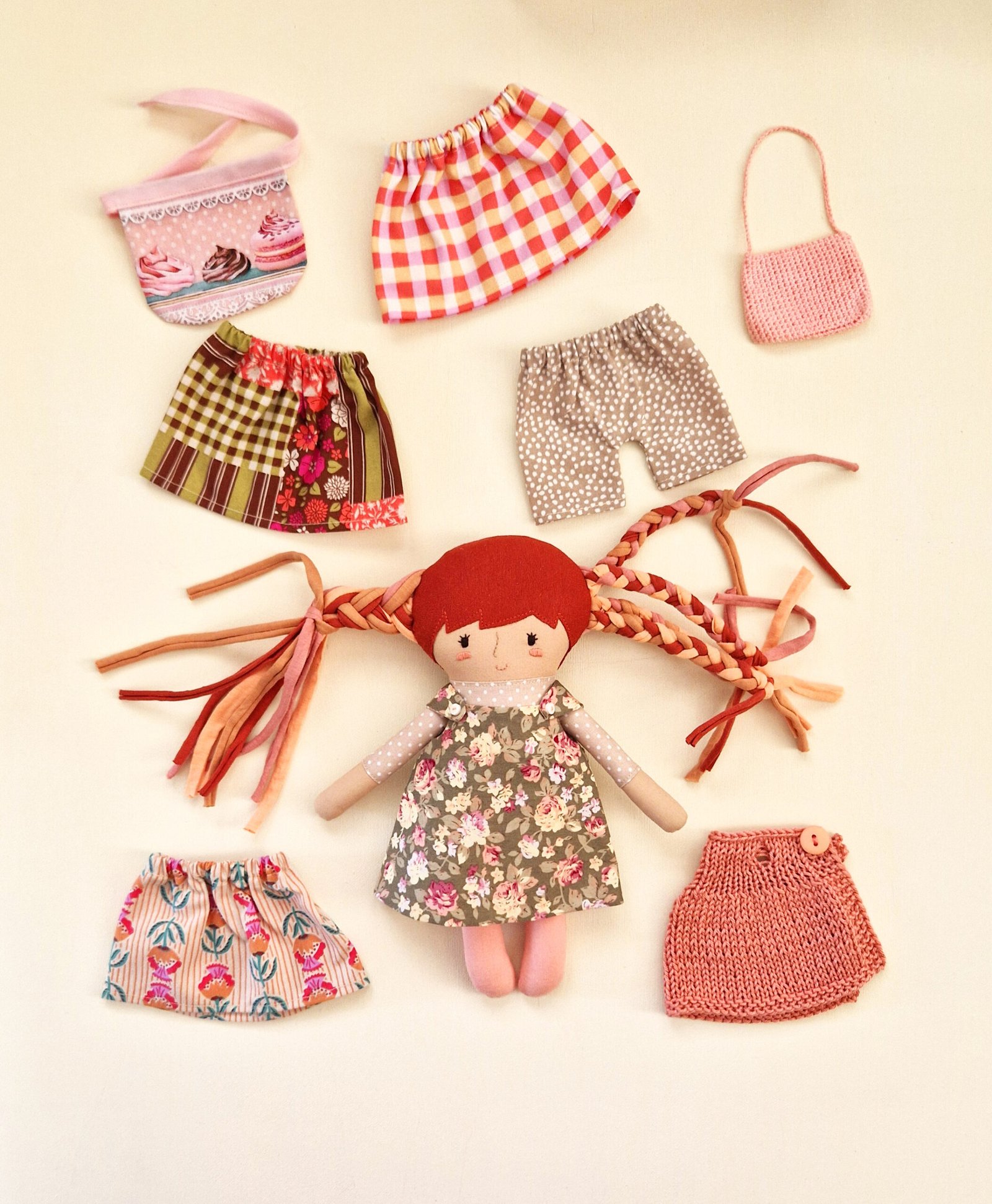 Soft play doll with a polka dot dress, small handbag, and colorful interchangeable clothes.
