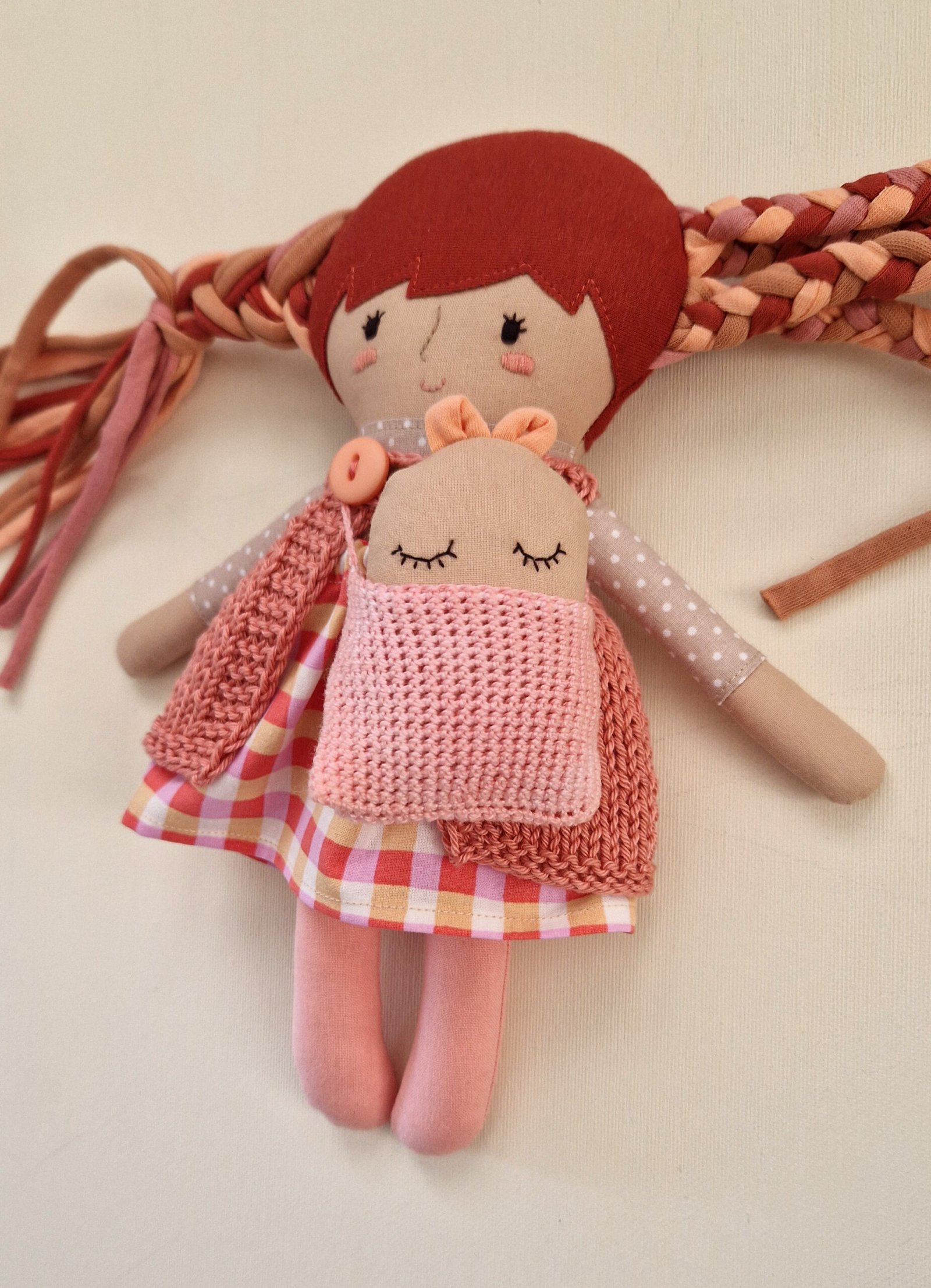 Fabric doll with colorful hair and a stylish collection of miniature outfits.