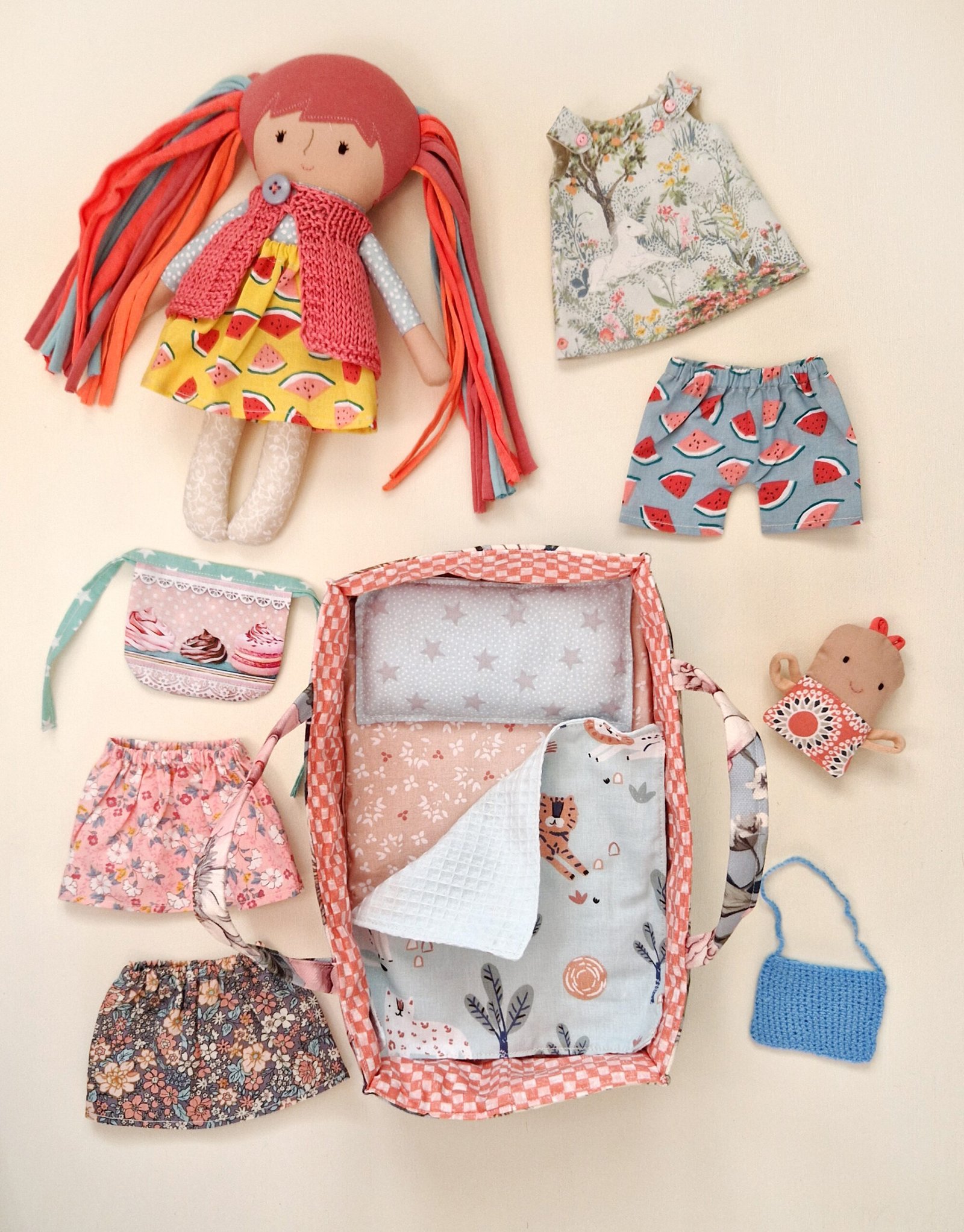 Children's doll bed with blanket, pillow and a variety of outfits