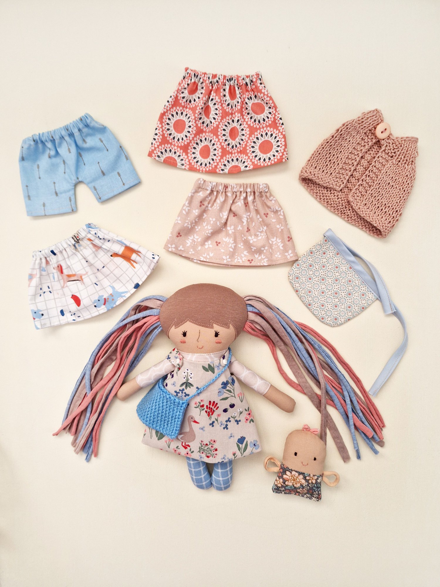 Soft play doll with checkered leggings and a selection of colorful skirts.