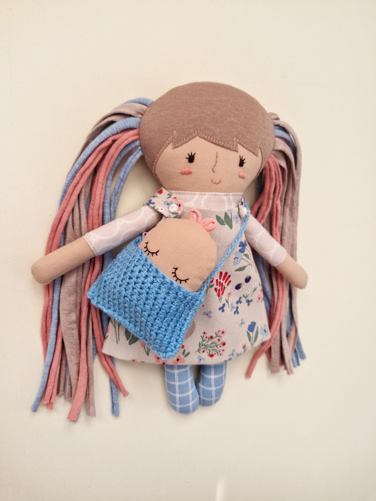Children's fabric doll with colorful hair and a variety of clothes and accessories.