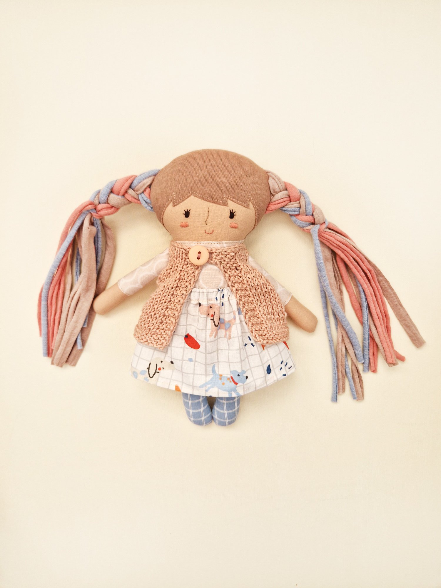 Fabric play doll set with miniature clothing and a large fabric carrying bag.