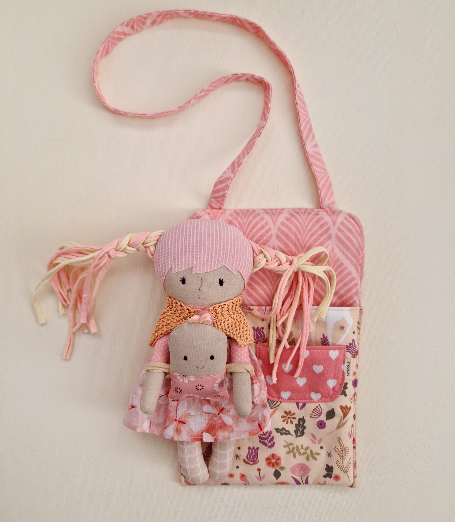 Doll play bag with interchangeable clothes and a small toy