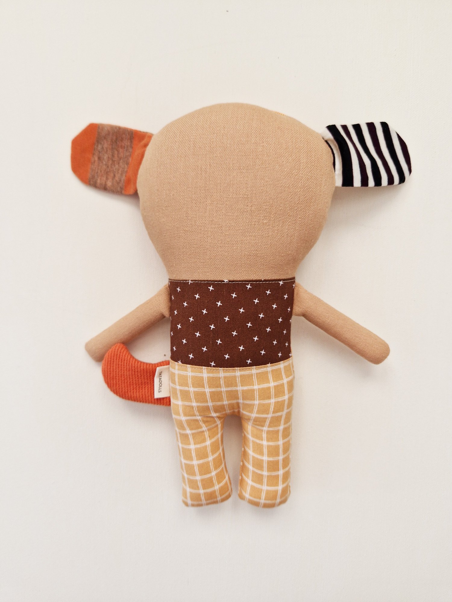 Handmade stuffed dog toy with colorful fabric patterns