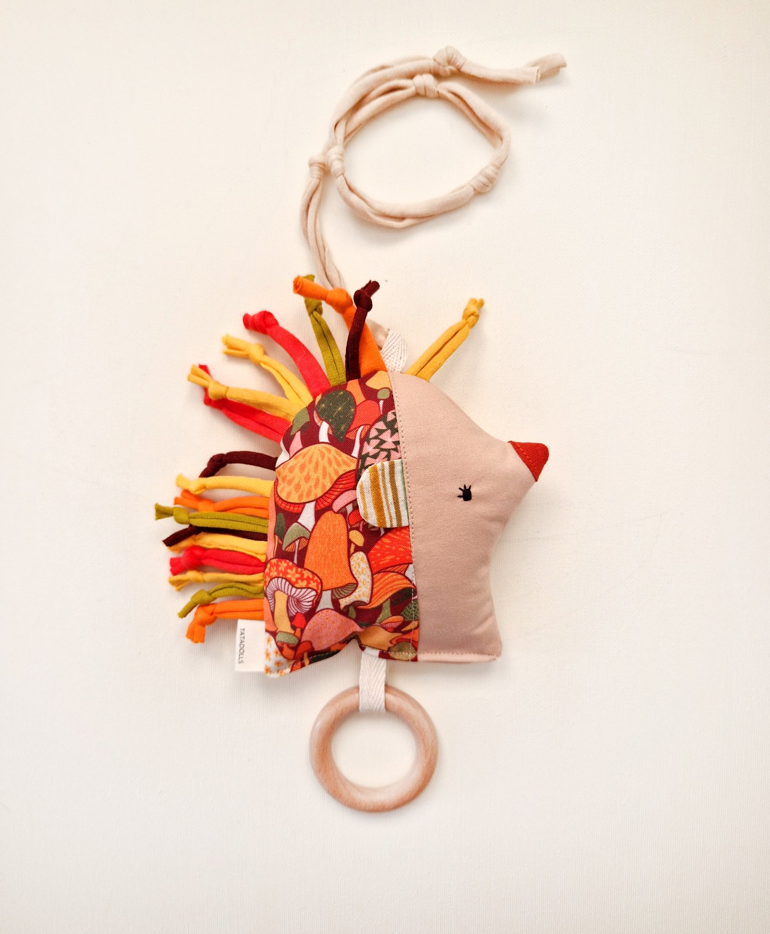 Double-sided fabric hedgehog rattle with colorful floral print and wooden teething ring