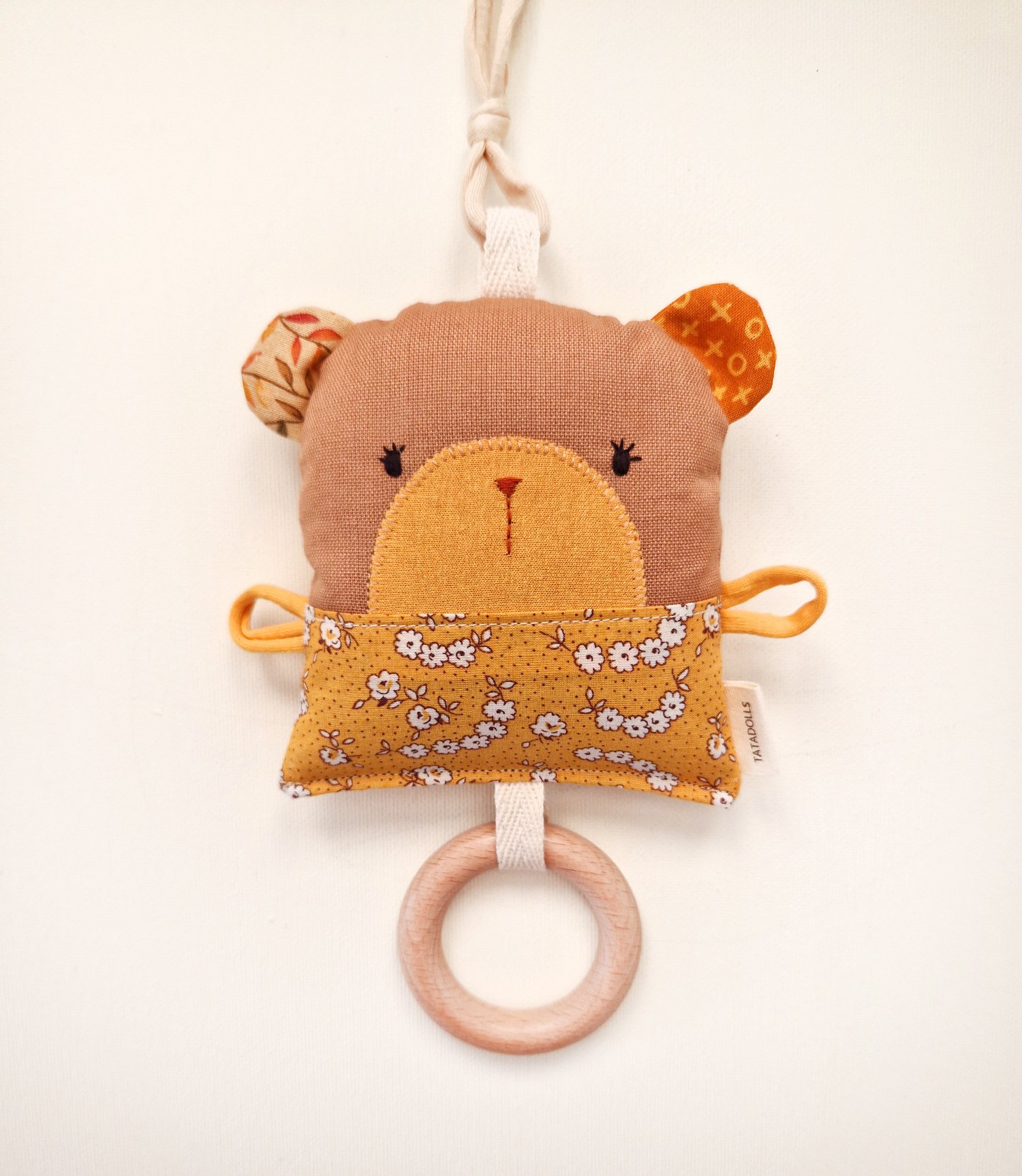 Double-sided fabric bear rattle with floral pocket and wooden teething ring