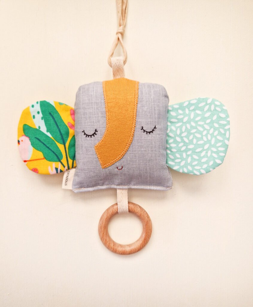 Double-sided fabric elephant rattle with colorful ears and wooden teething ring