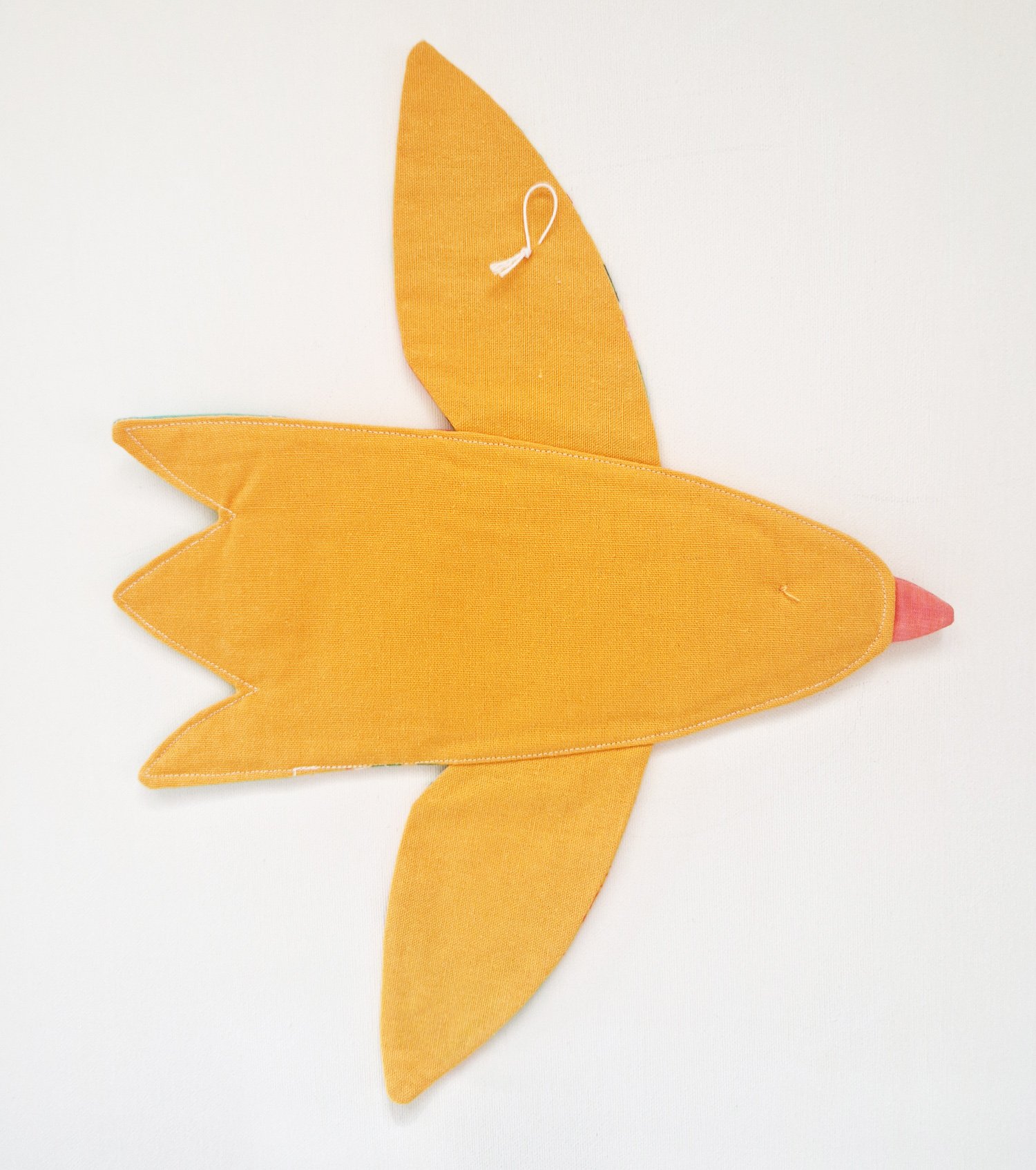 Handmade colorful yellow tropical bird wall hanging made from patterned cotton fabrics