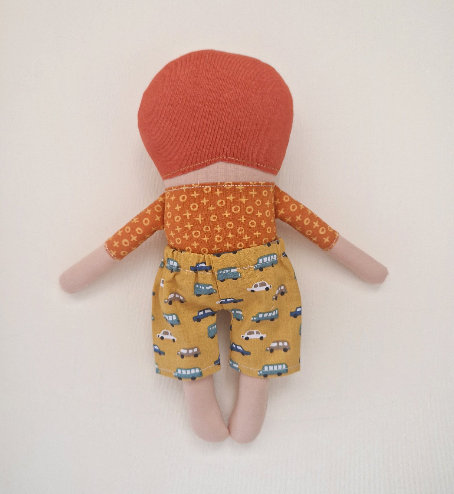 Handmade fabric doll with red hair, orange shirt and yellow car print shorts