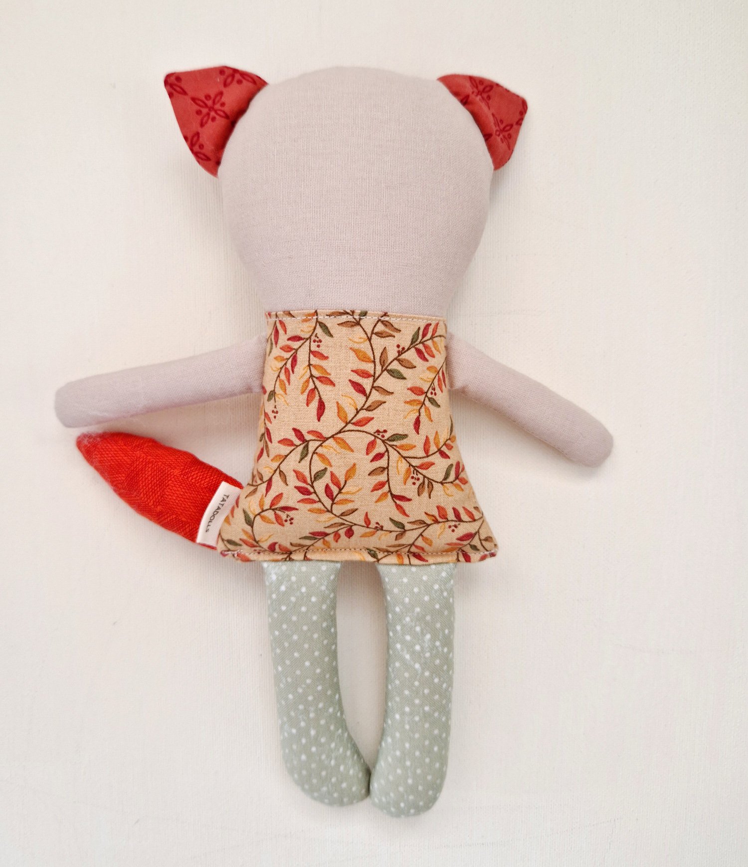 Cute handmade textile fox toy with patterned dress and grey polka dot legs