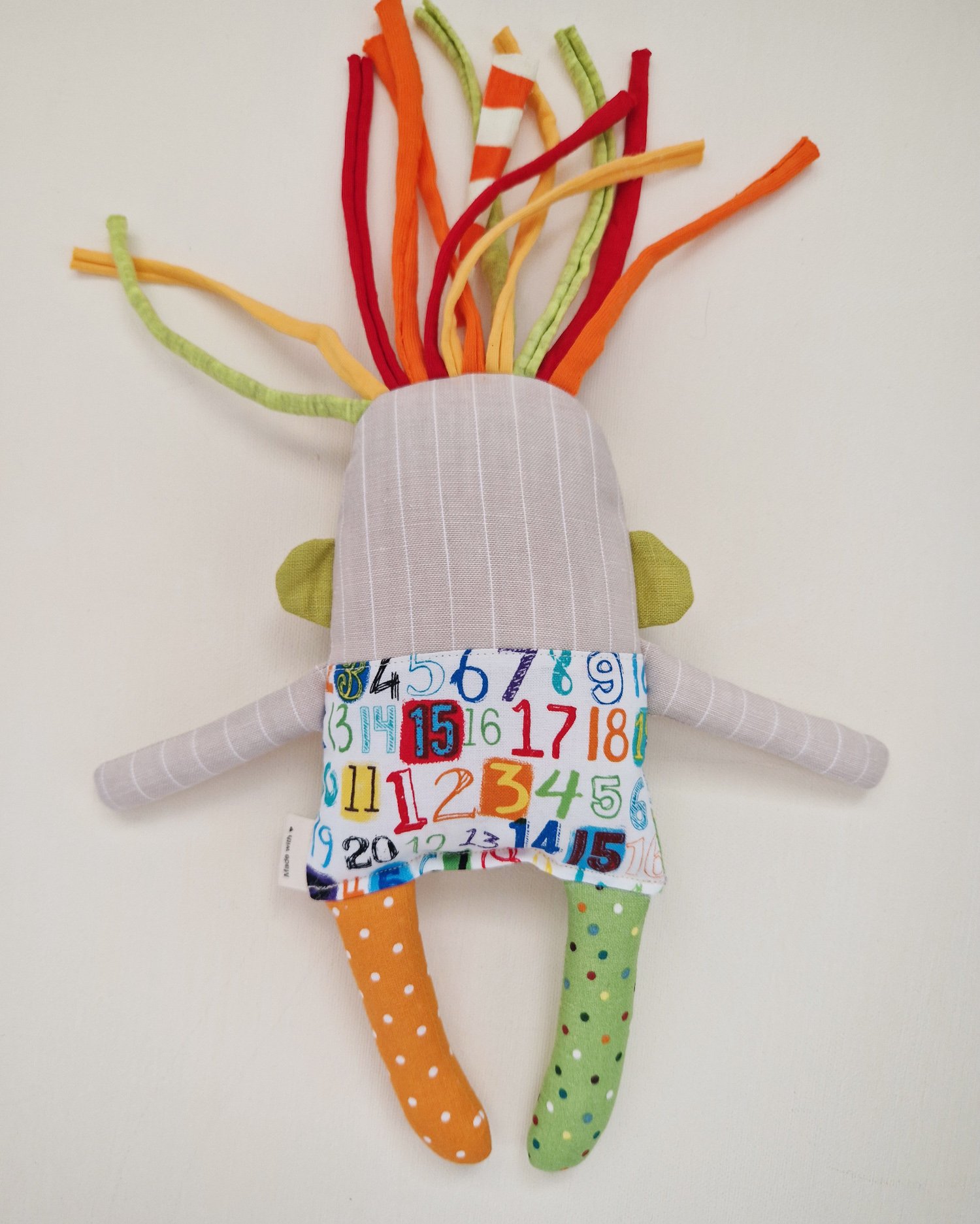 Original soft textile doll with playful colorful details and mismatched patterned legs