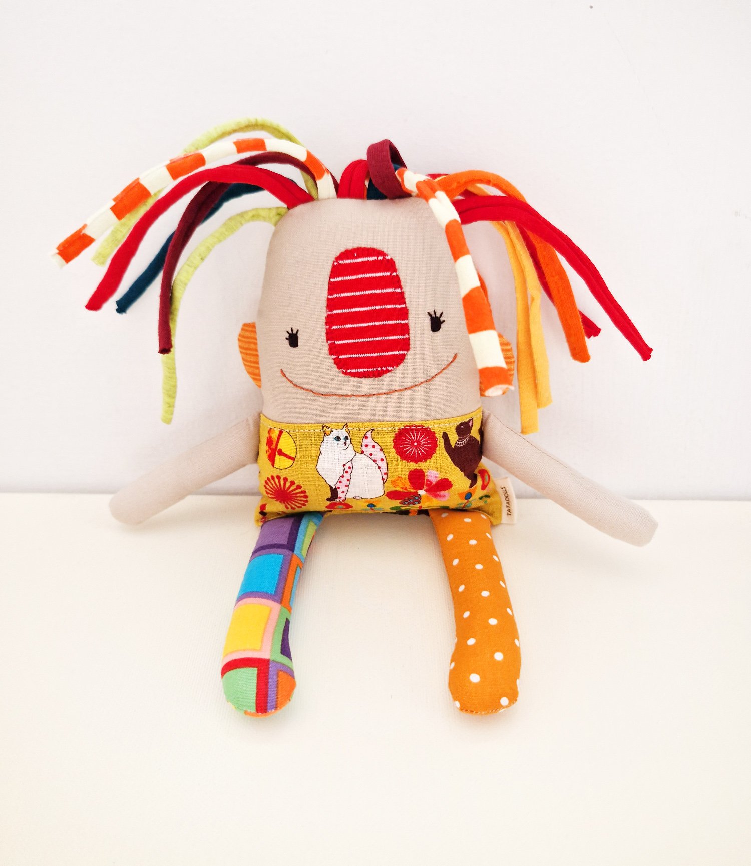 Original handmade fabric doll with bright mismatched legs and a skirt featuring Japanese-inspired cats and flowers
