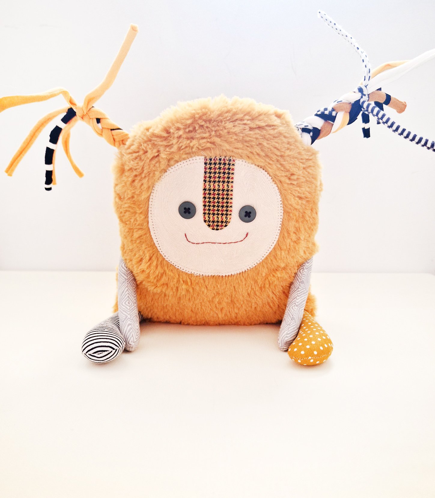 Cute artistic rag doll with yellow faux fur, colorful braided ribbons and patchwork details
