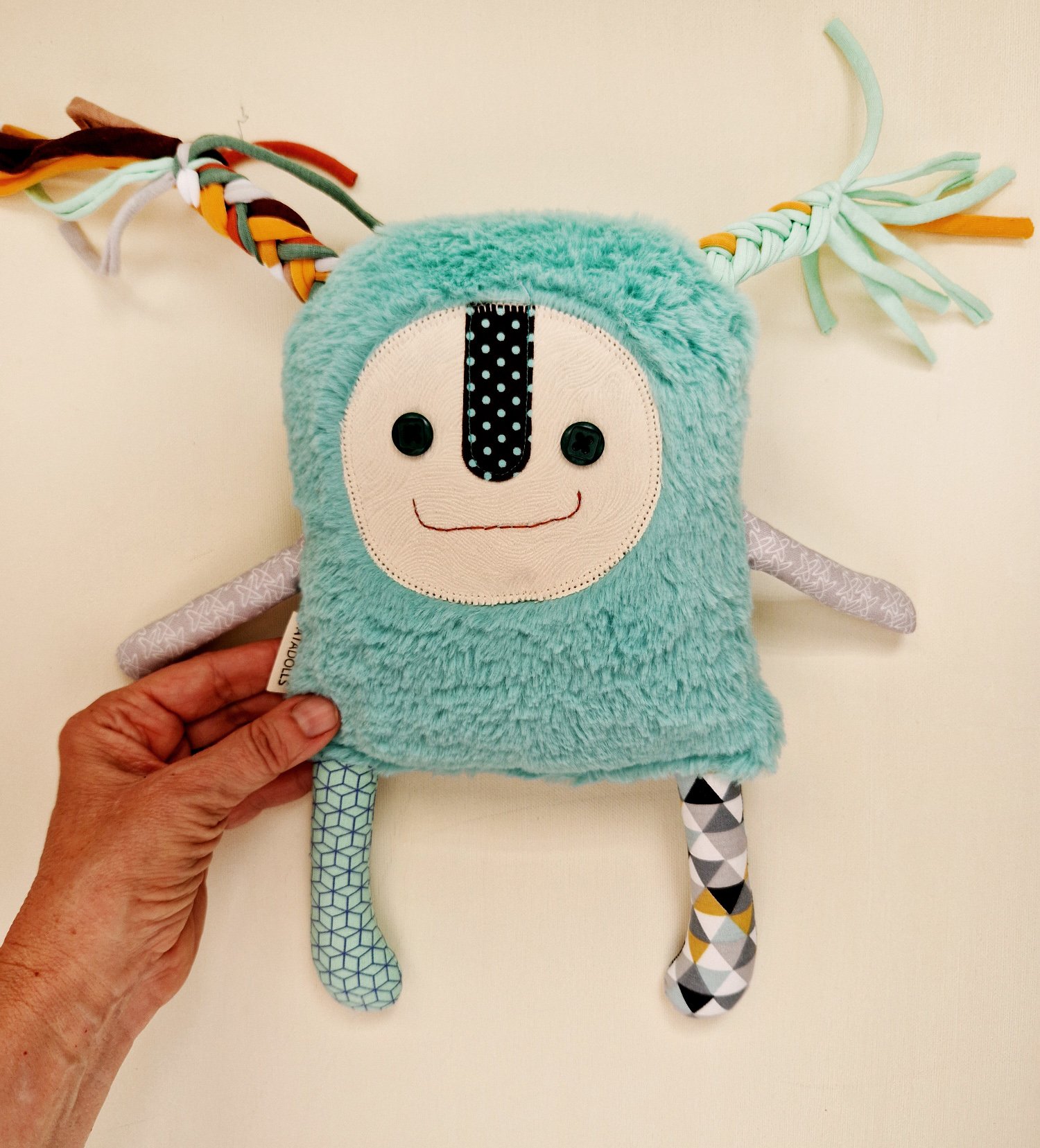 Unique handmade textile doll with a soft turquoise furry body, button eyes and geometric fabric legs
