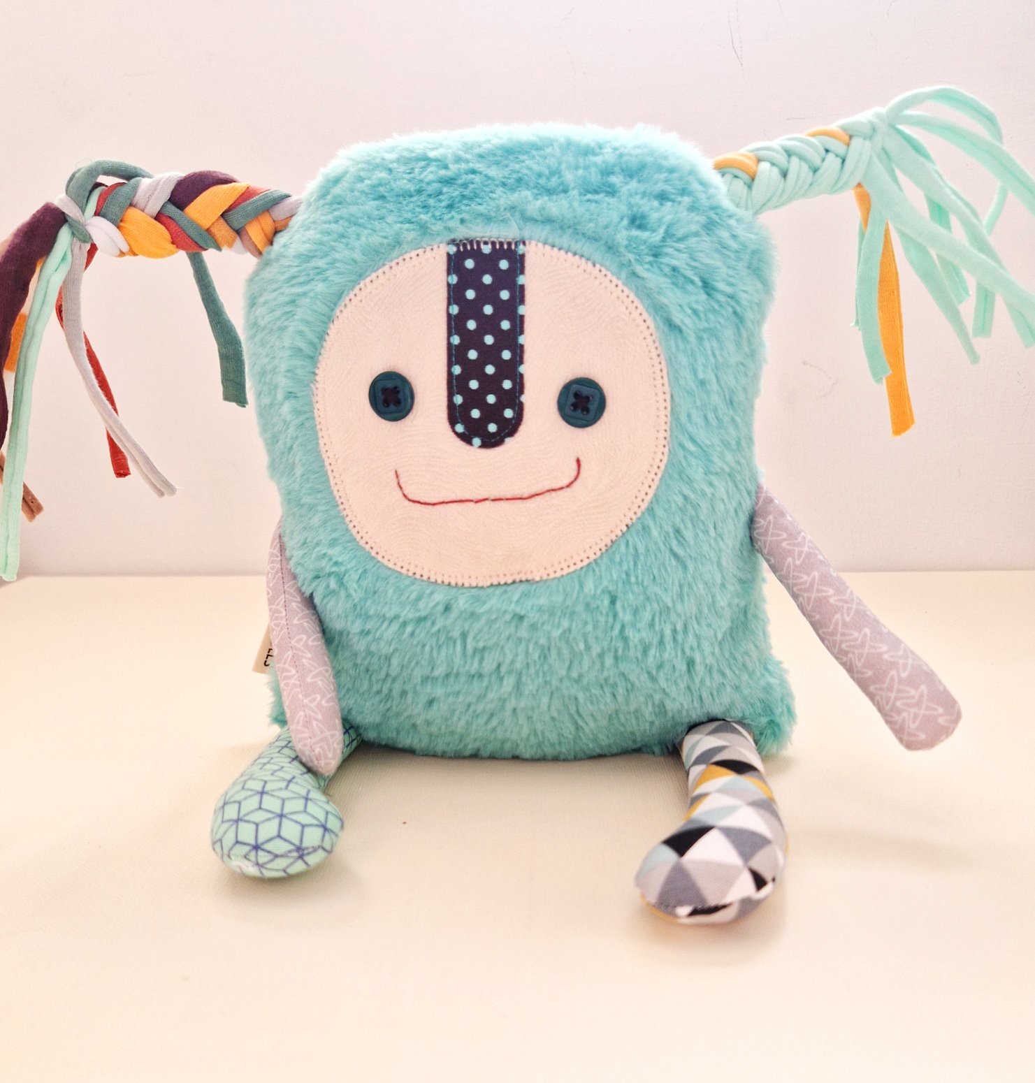 Cute artistic rag doll with turquoise faux fur, colorful braided ribbons and patchwork details