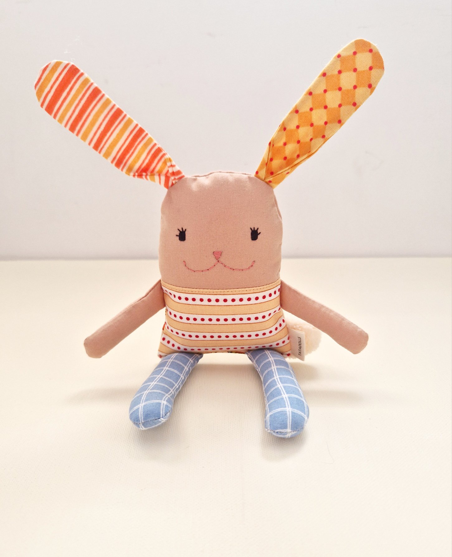 Soft reversible bunny doll with colorful patterned ears and butterfly print