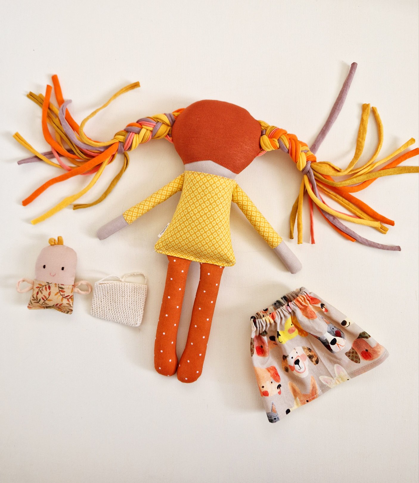 Soft handmade rag doll with orange legs and colorful fabric hair for children's play